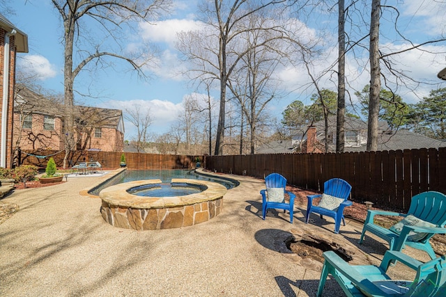 view of pool with an in ground hot tub, a fenced backyard, and a patio area