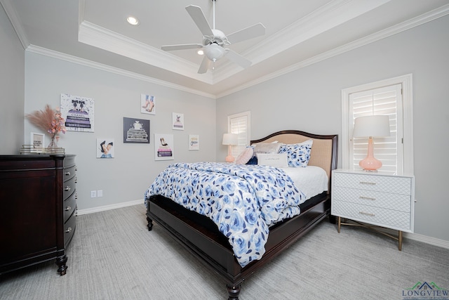 bedroom featuring baseboards, a raised ceiling, light colored carpet, and crown molding