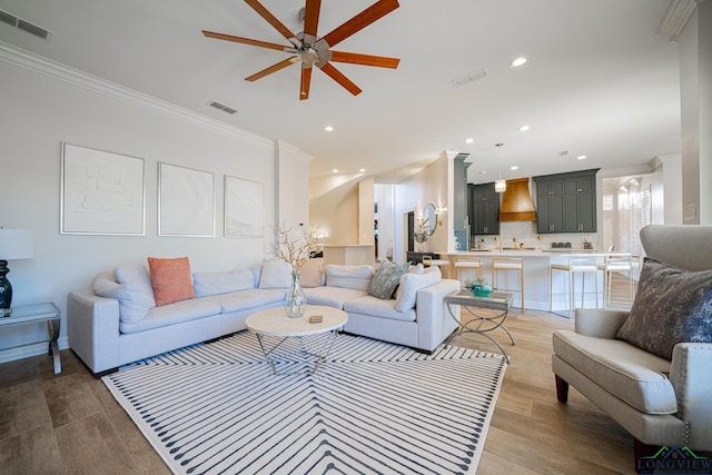 living room featuring visible vents and ornamental molding