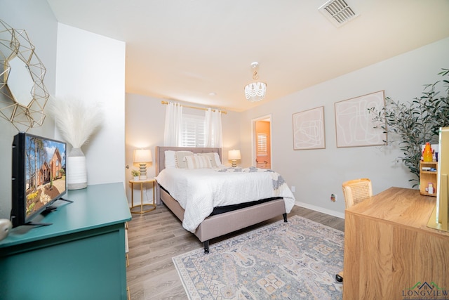 bedroom featuring light wood-style flooring, baseboards, and visible vents