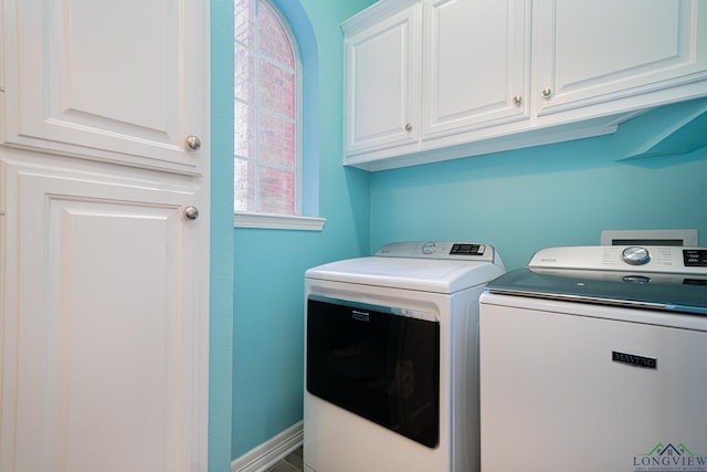 laundry room with cabinet space, washing machine and dryer, and baseboards