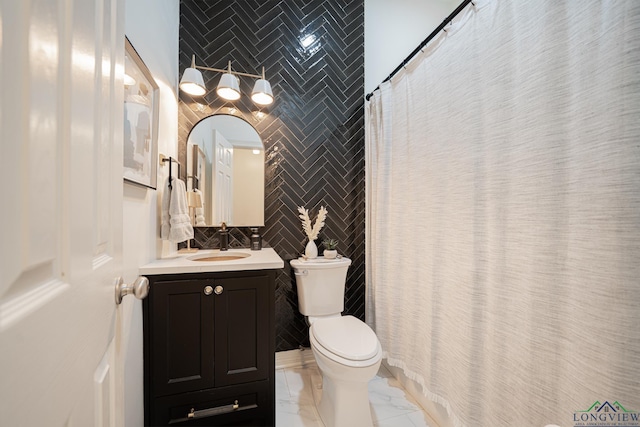 bathroom featuring tile walls, toilet, a shower with shower curtain, marble finish floor, and vanity