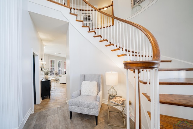 staircase with baseboards and a towering ceiling