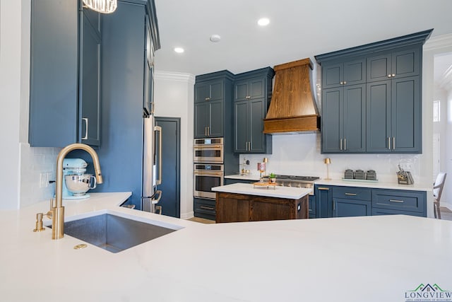 kitchen featuring light countertops, ornamental molding, custom exhaust hood, stainless steel appliances, and a sink