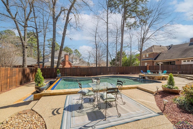 view of swimming pool with a pool with connected hot tub, a fenced backyard, and a patio area