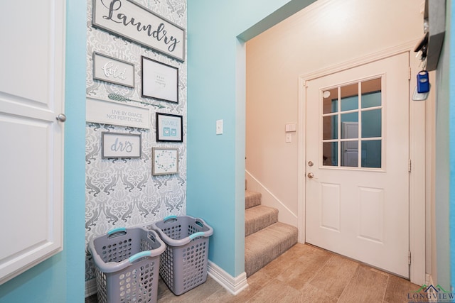 doorway with stairway, baseboards, and wood finished floors