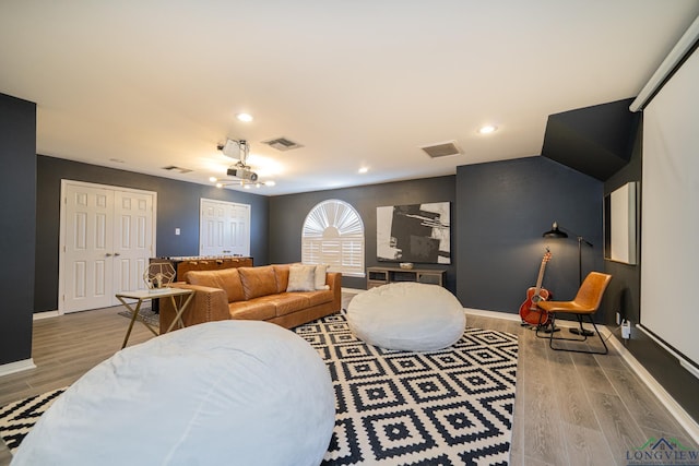 living area with recessed lighting, visible vents, baseboards, and wood finished floors