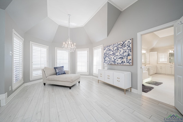 living area featuring high vaulted ceiling, baseboards, light wood-type flooring, and a chandelier