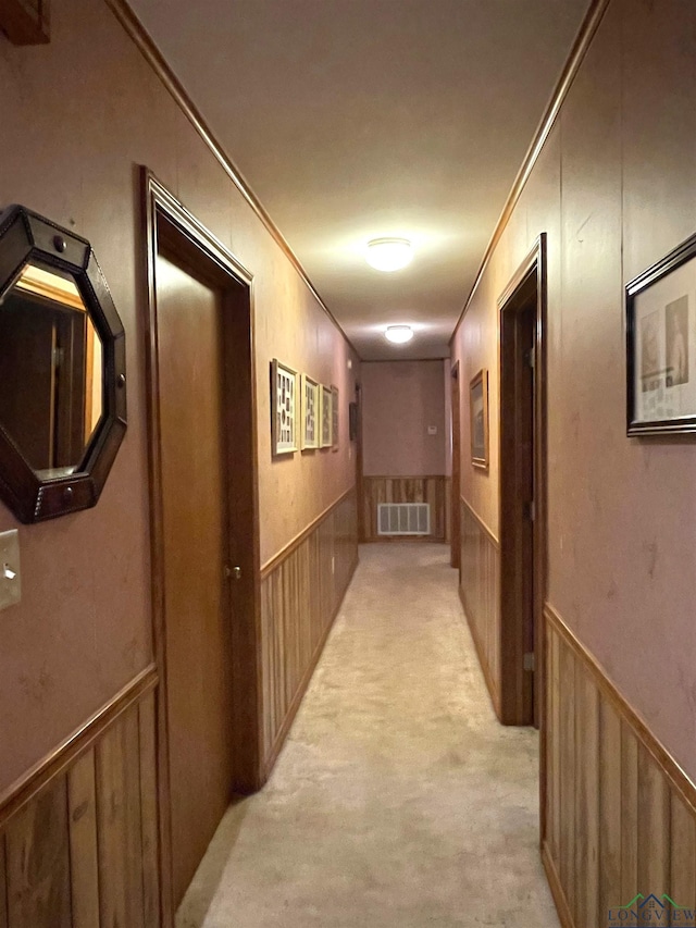 corridor with light colored carpet and crown molding