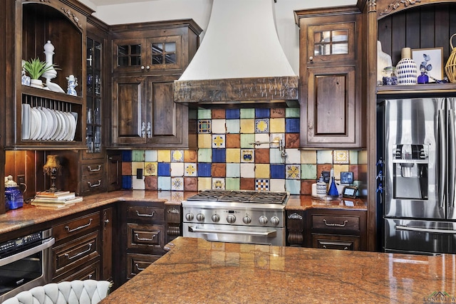 kitchen with dark brown cabinetry, premium range hood, and stainless steel appliances