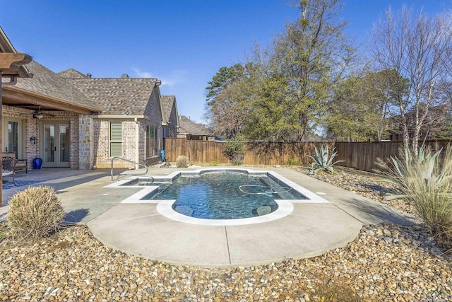 view of swimming pool with ceiling fan, a patio, and french doors