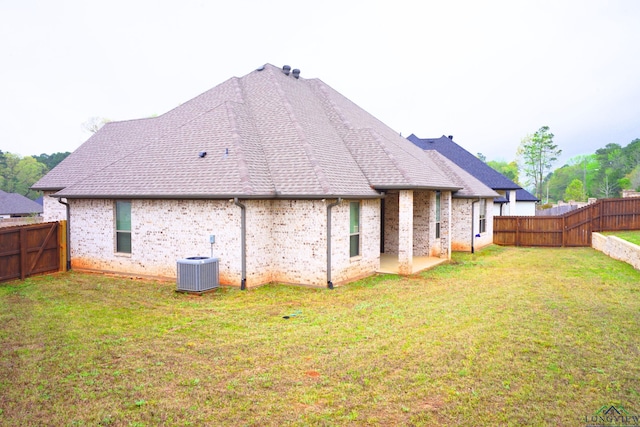 9173 Cave Branch Cv, Tyler, TX 75703 - back of house with a fenced backyard, central air condition unit, brick siding, and a yard
