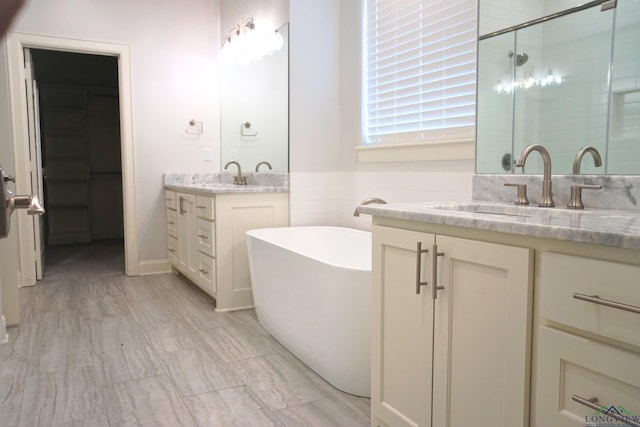 9173 Cave Branch Cv, Tyler, TX 75703 - bathroom with a freestanding tub, a sink, a stall shower, and two vanities