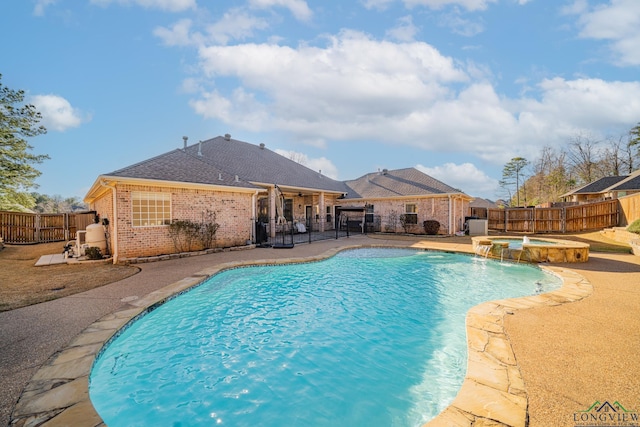 view of pool featuring a patio area, a fenced backyard, and a pool with connected hot tub