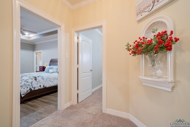 corridor featuring carpet, ornamental molding, and baseboards