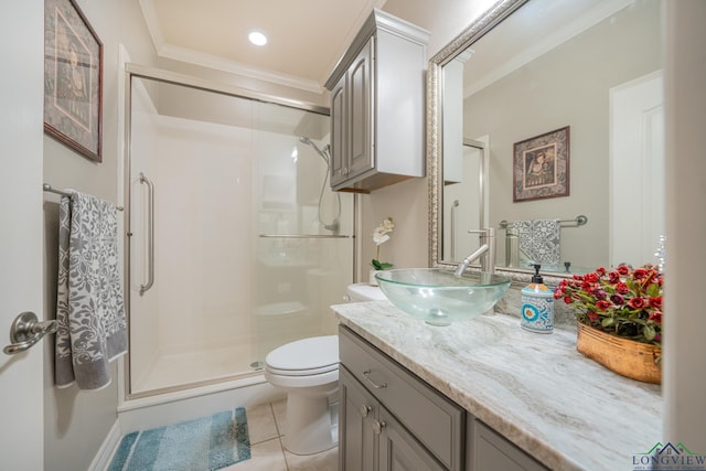 bathroom featuring tile patterned flooring, toilet, vanity, ornamental molding, and a stall shower