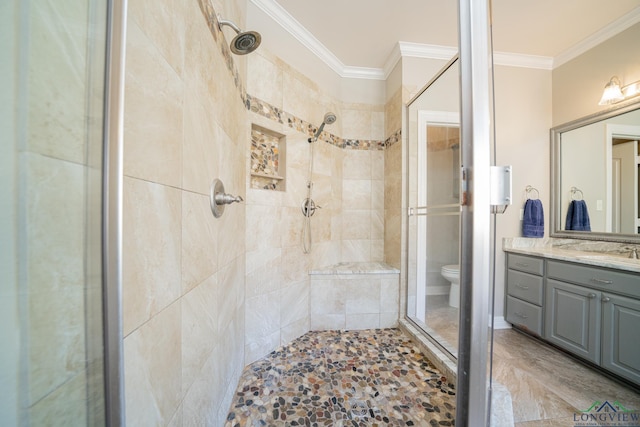 bathroom featuring a stall shower, crown molding, vanity, and toilet