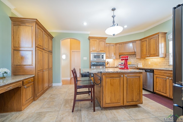 kitchen featuring arched walkways, decorative backsplash, custom range hood, light stone counters, and stainless steel appliances