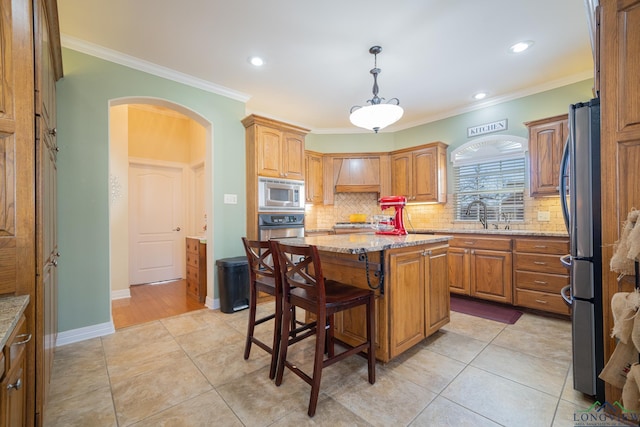 kitchen with arched walkways, stainless steel appliances, ornamental molding, and a sink