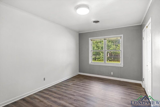 unfurnished bedroom with ornamental molding, dark wood-style floors, and baseboards