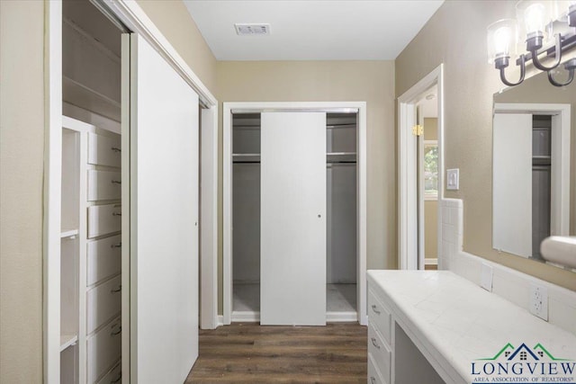 bathroom with a chandelier and wood finished floors
