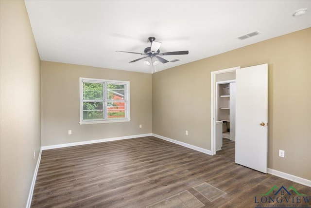 spare room featuring dark wood-style floors, baseboards, a ceiling fan, and a smoke detector