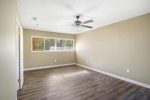 spare room featuring baseboards, dark wood-style flooring, and a ceiling fan