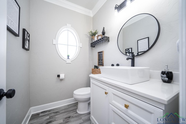 bathroom with toilet, hardwood / wood-style floors, vanity, and ornamental molding