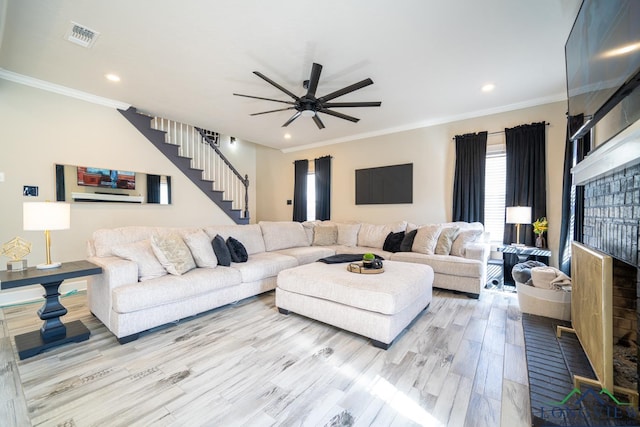 living room featuring crown molding, ceiling fan, and light wood-type flooring