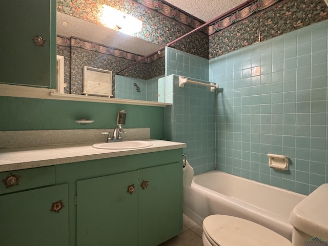 full bathroom with tiled shower / bath combo, vanity, tile patterned flooring, and toilet