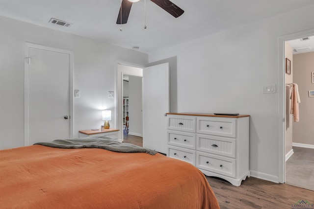 bedroom with wood finished floors, visible vents, a ceiling fan, and baseboards