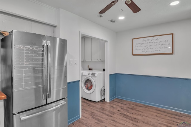 laundry area featuring wood finished floors, visible vents, a ceiling fan, washer / dryer, and cabinet space