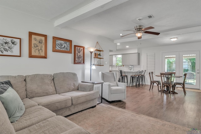 living room with visible vents, recessed lighting, beamed ceiling, a ceiling fan, and wood finished floors