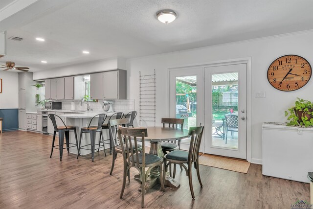 dining area with a ceiling fan, wood finished floors, baseboards, ornamental molding, and recessed lighting