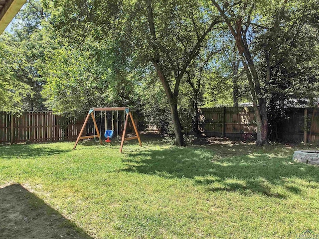 view of yard with a fenced backyard and a playground