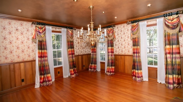 interior space with a healthy amount of sunlight, wood-type flooring, and crown molding