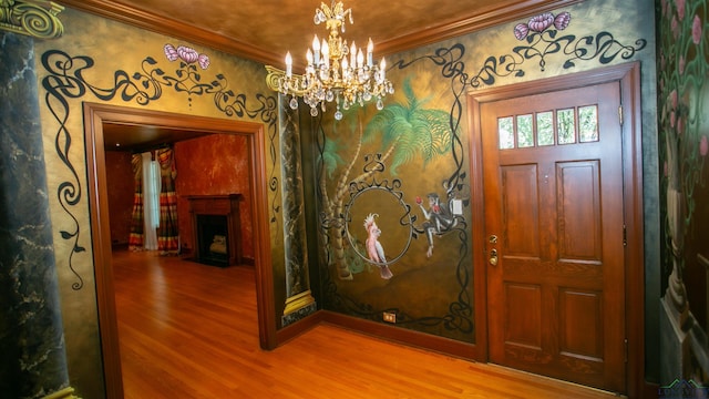 foyer featuring crown molding, hardwood / wood-style floors, and a notable chandelier