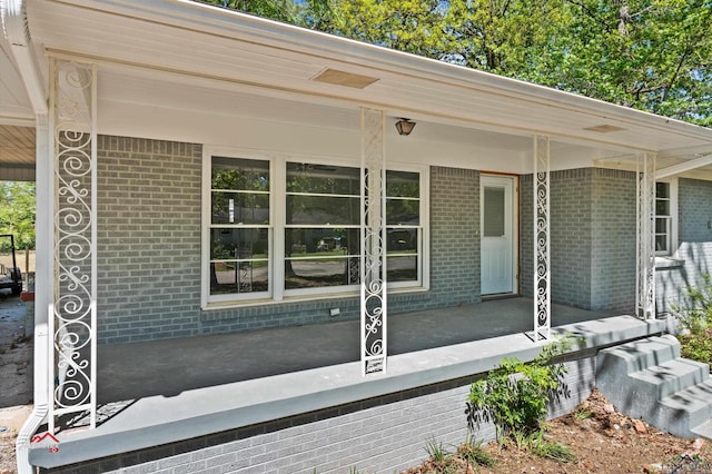 view of exterior entry featuring covered porch