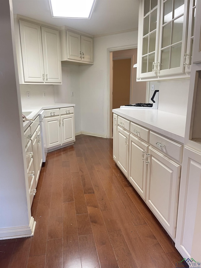 1404 Stonebriar Dr, Carthage, TX 75633 - kitchen featuring light countertops, baseboards, glass insert cabinets, white cabinets, and dark wood-style flooring