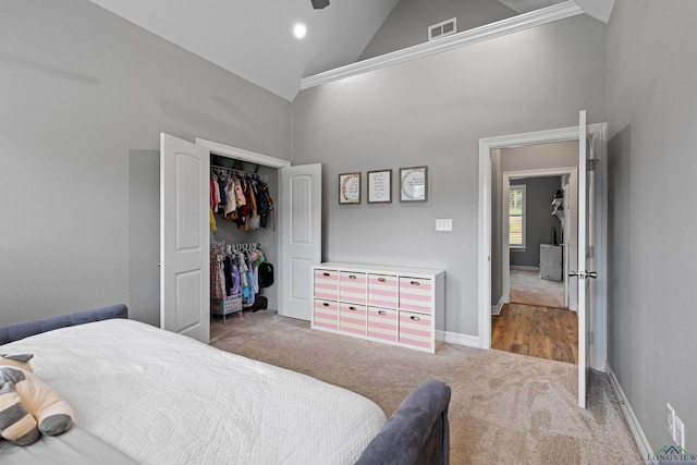 bedroom with carpet floors, high vaulted ceiling, and a closet