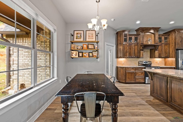 dining area with a chandelier and light hardwood / wood-style floors