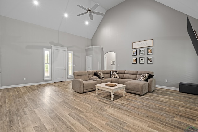 living room featuring ceiling fan, light wood-type flooring, and high vaulted ceiling