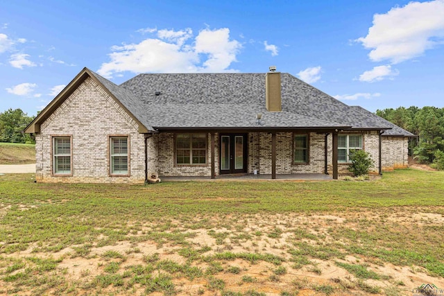 rear view of property with a patio and a lawn