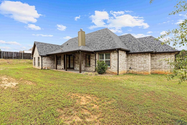 rear view of house featuring a lawn and a patio area