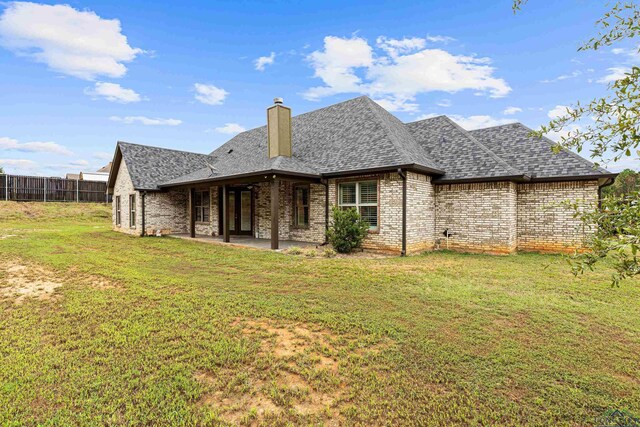 rear view of house featuring a lawn and a patio area