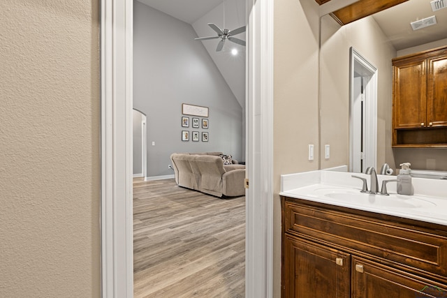 bathroom featuring hardwood / wood-style floors, ceiling fan, lofted ceiling, and vanity