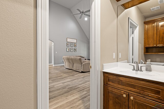 bathroom featuring hardwood / wood-style floors, ceiling fan, lofted ceiling, and vanity