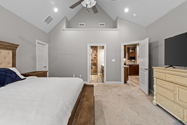 carpeted bedroom with ensuite bathroom, ceiling fan, and high vaulted ceiling