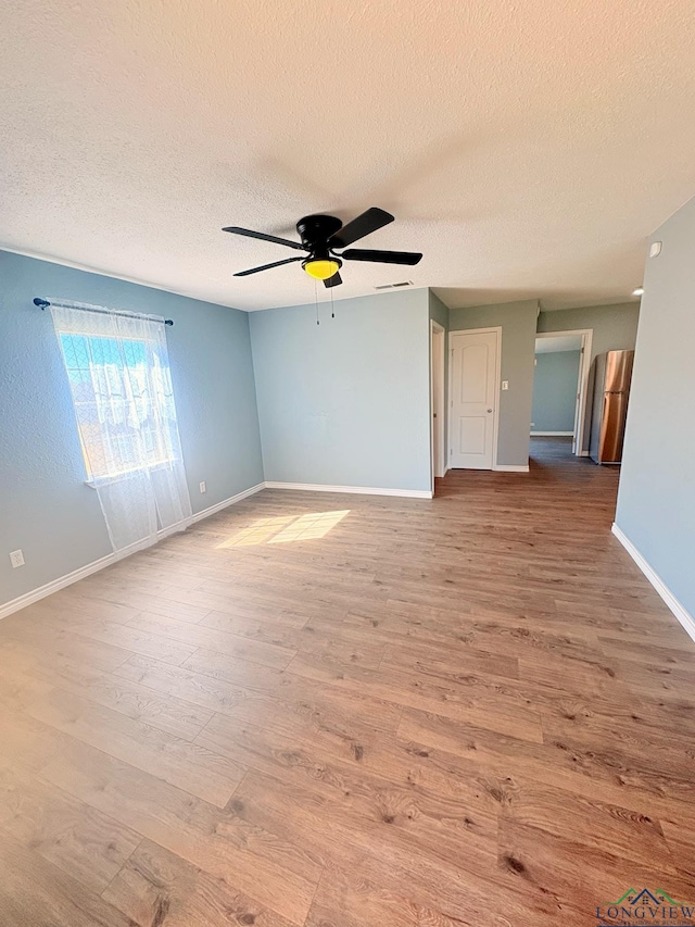 unfurnished room featuring a ceiling fan, baseboards, and wood finished floors