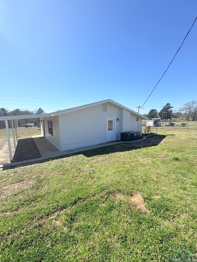 view of side of property with a patio, a yard, and central AC unit